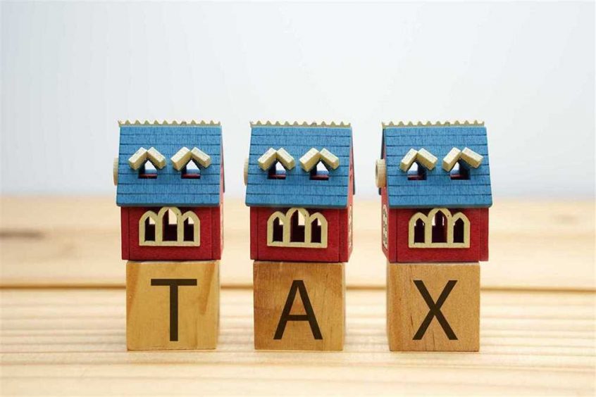 blocks with the word tax spelt out and mini homes on top to symbolize tax for your homes
